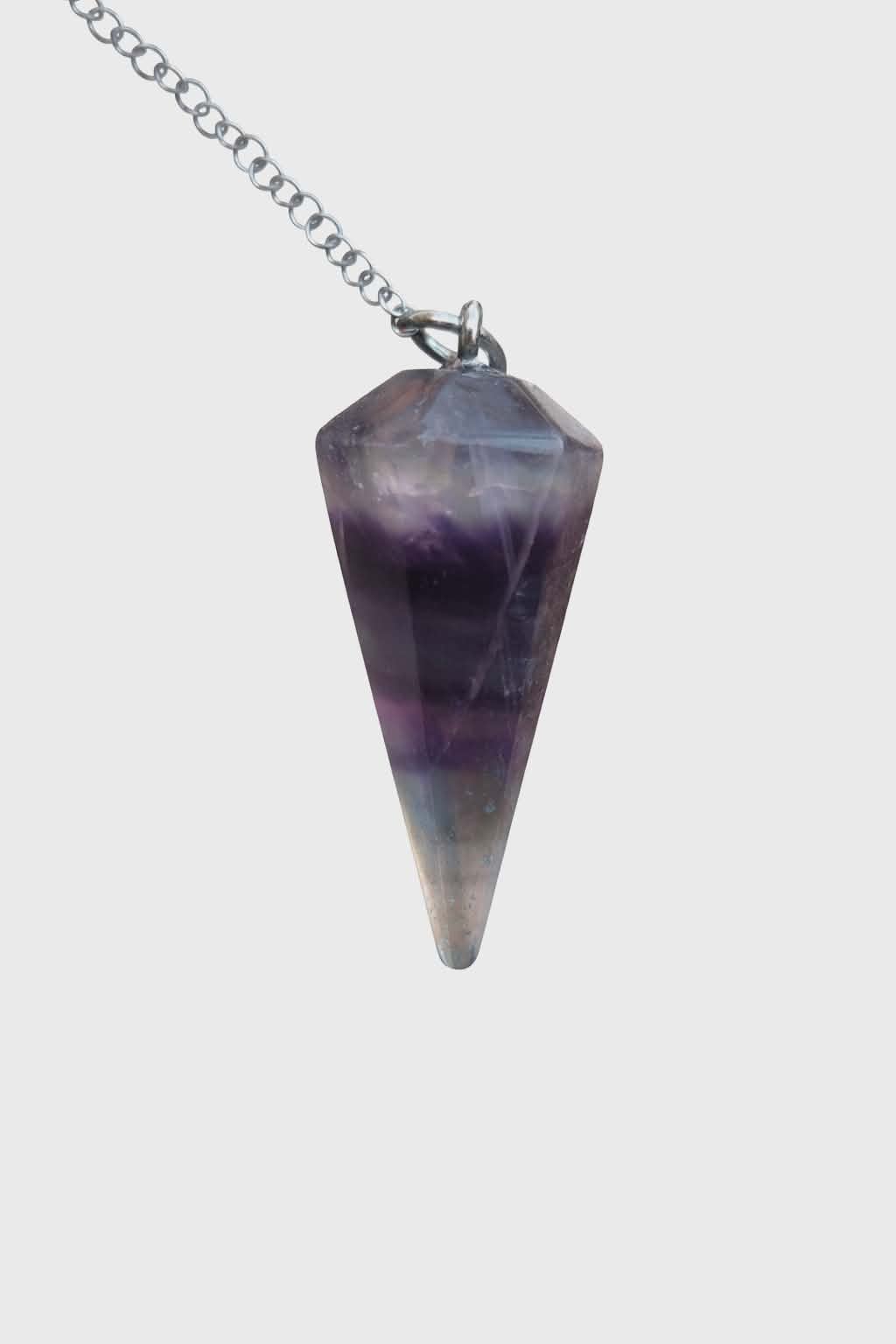 Pendule en fluorite multicolore facettée (violet, bleu, vert) sur chaîne argentée, fond blanc, favorise la clarté mentale, l’apaisement et l’équilibre émotionnel.