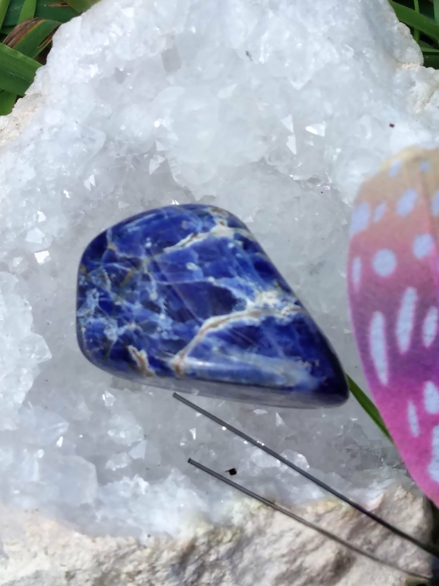 Pierre roulée de sodalite bleu profond veinée de blanc sur amas de quartz avec encens et décor champignon, galet naturel associé à la lucidité, à la paix émotionnelle et à l’écoute de soi.