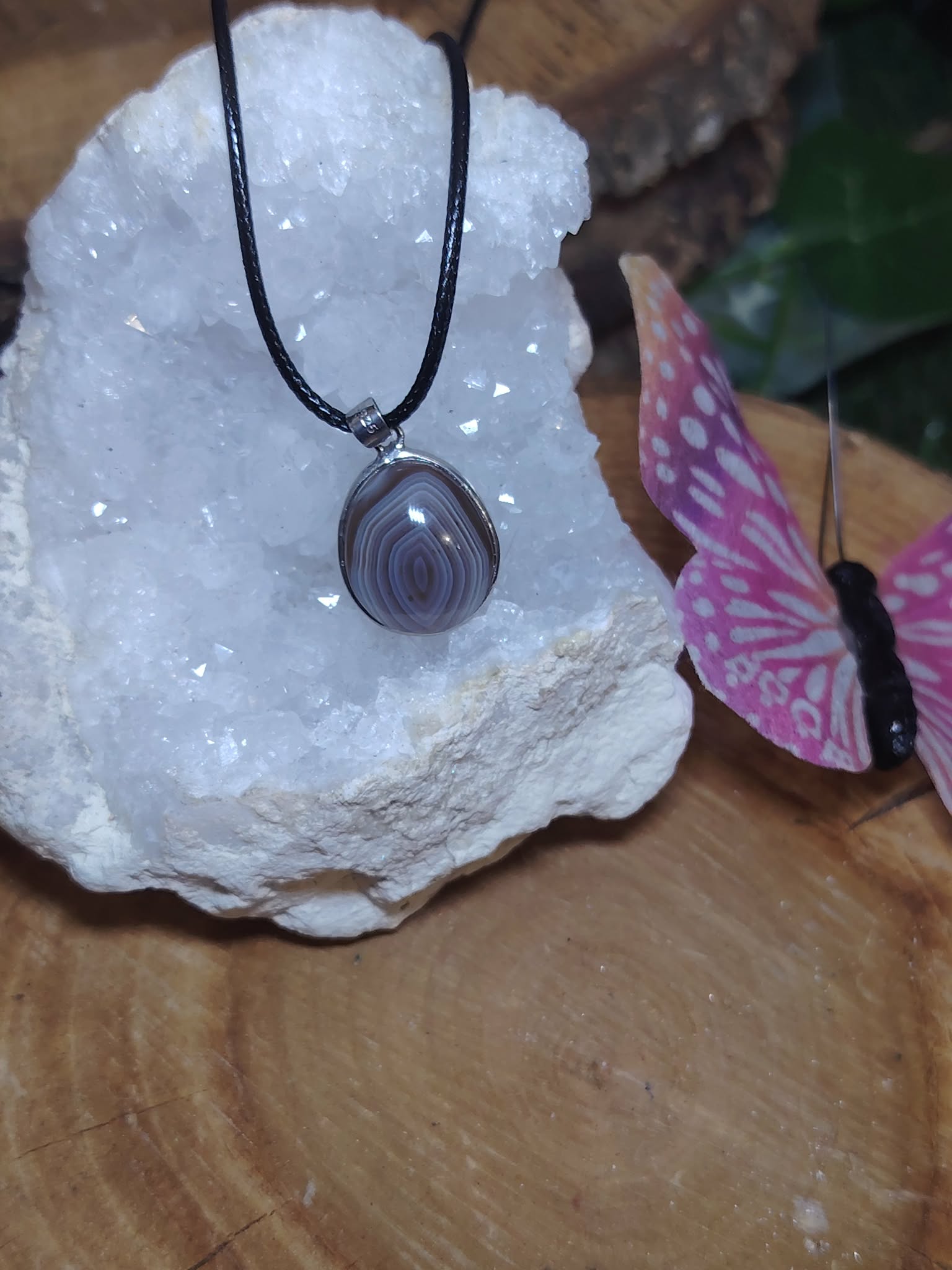 Pendentif agate du Botswana en goutte sur géode blanche et support bois avec papillon rose, bijou argenté au style délicat et rassurant