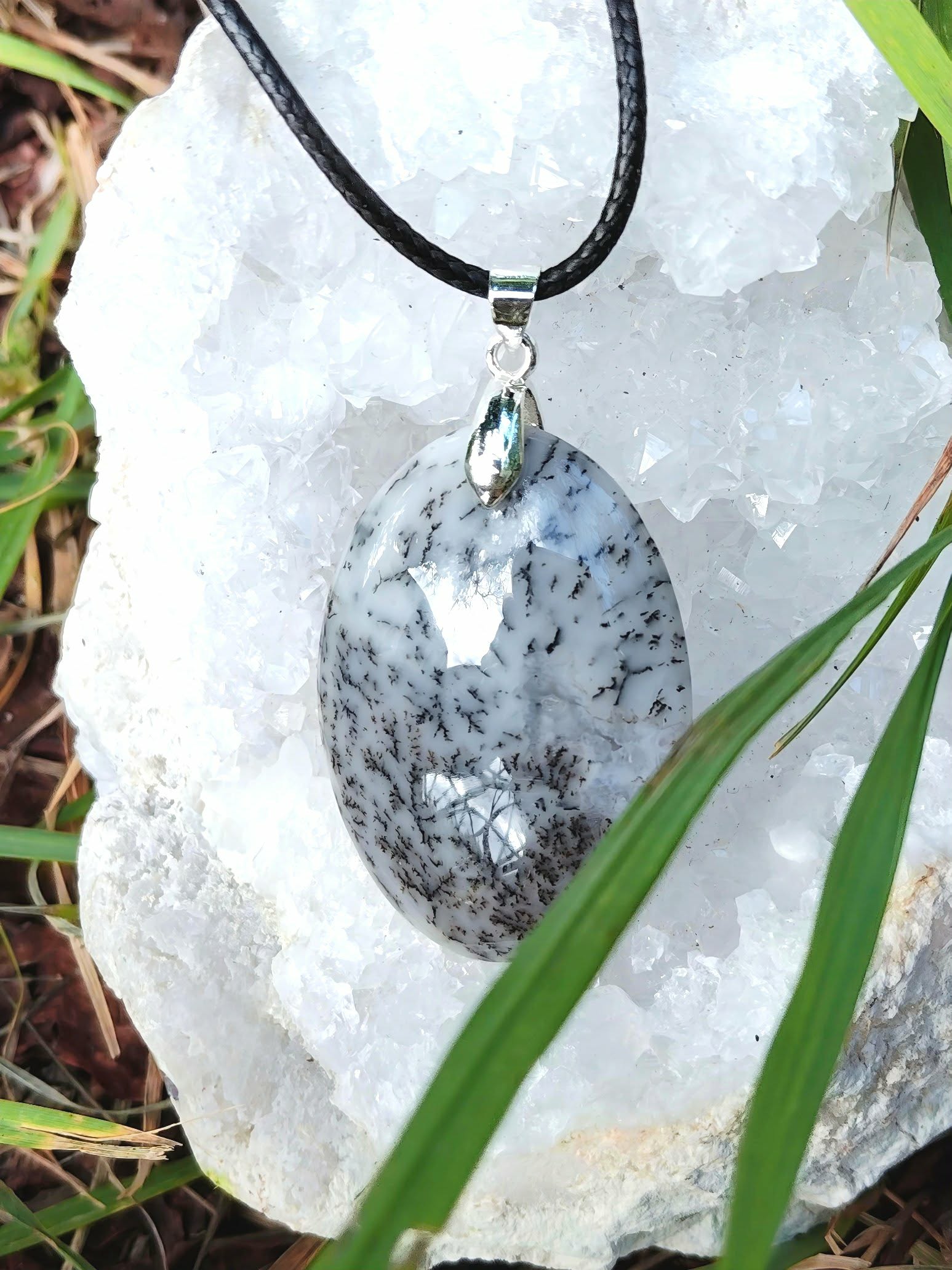 Pendentif opale dendritique ovale avec cordon noir et bélière argentée, décor nature avec feuilles vertes, stabilité douce et esprit plus net
