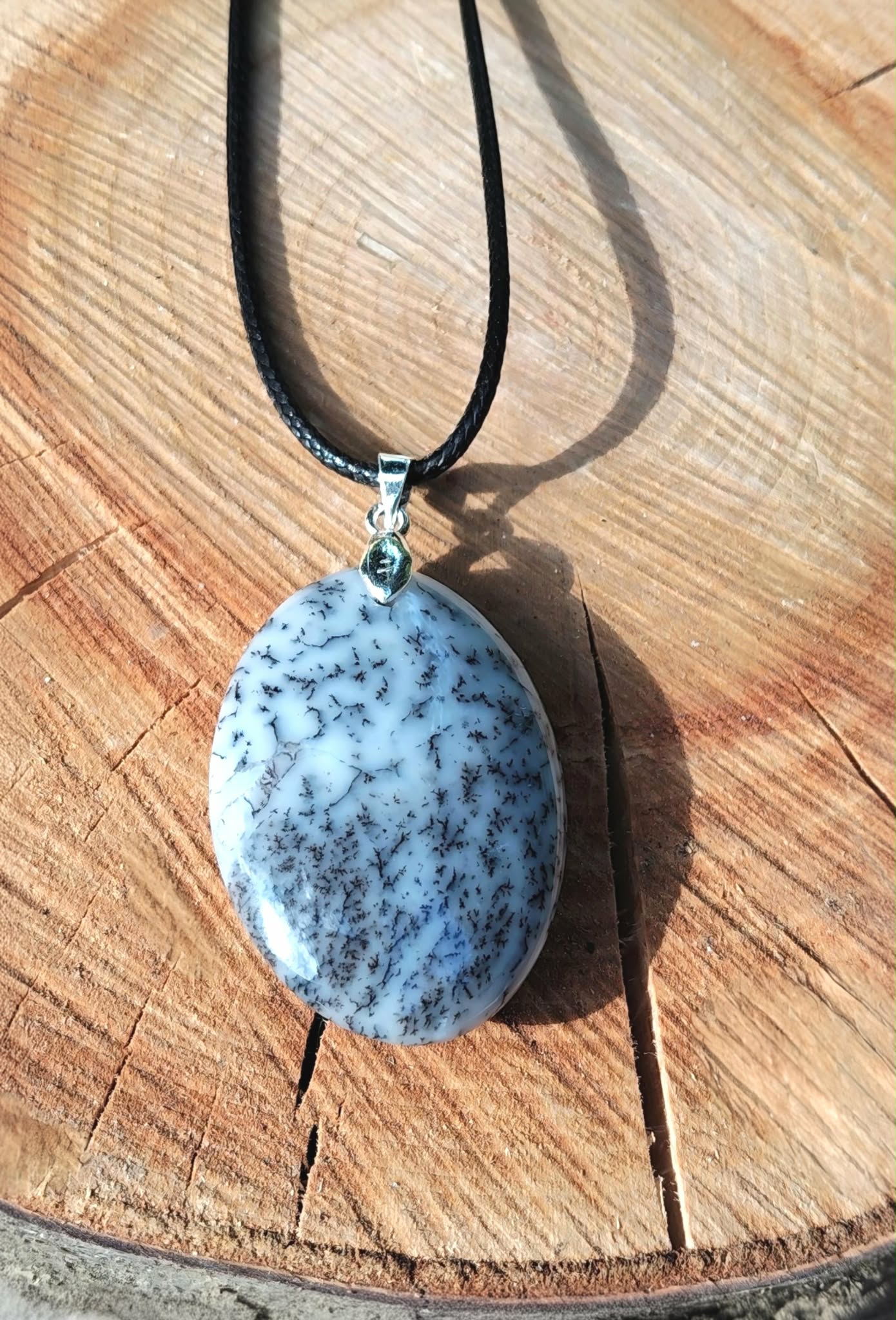 Pendentif opale dendritique sur bois clair avec cordon noir et bélière argentée, harmonie intérieure et discernement tranquille