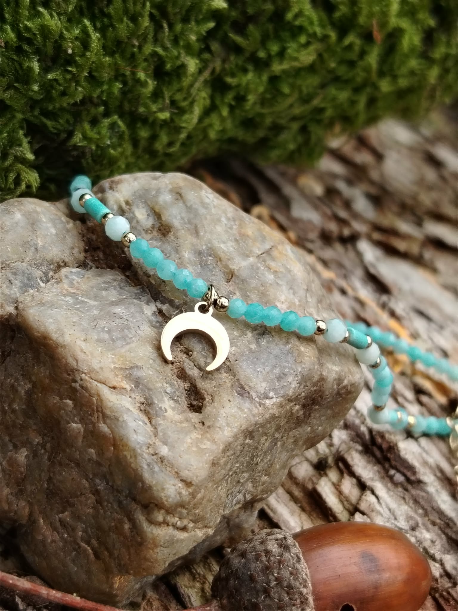 Collier amazonite bleu-vert avec pendentif lune sur rochers en Bretagne, sérénité intérieure, lâcher-prise et expression plus fluide