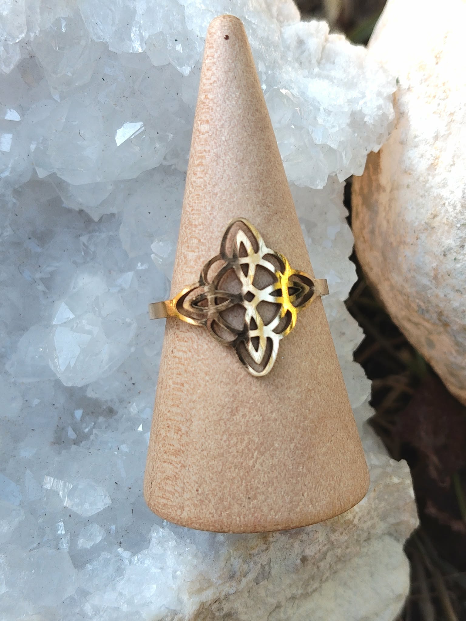 Bague réglable nœud de sorcière, acier inoxydable doré, photo sur cône, ambiance roche/minéral; symbole de lien protecteur.