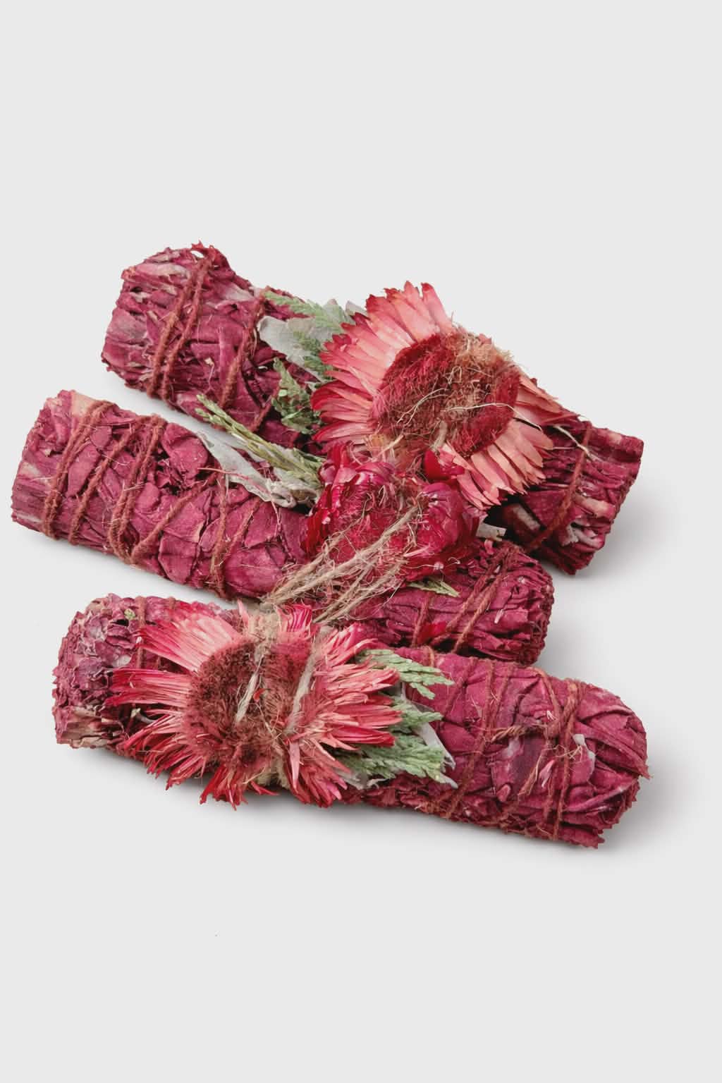 Bâton de fumigation sauge blanche “sang de dragon”, fagots rouges avec fleurs séchées, ficelle naturelle, photo sur fond blanc; idéal pour purifier une pièce et poser une intention de protection.