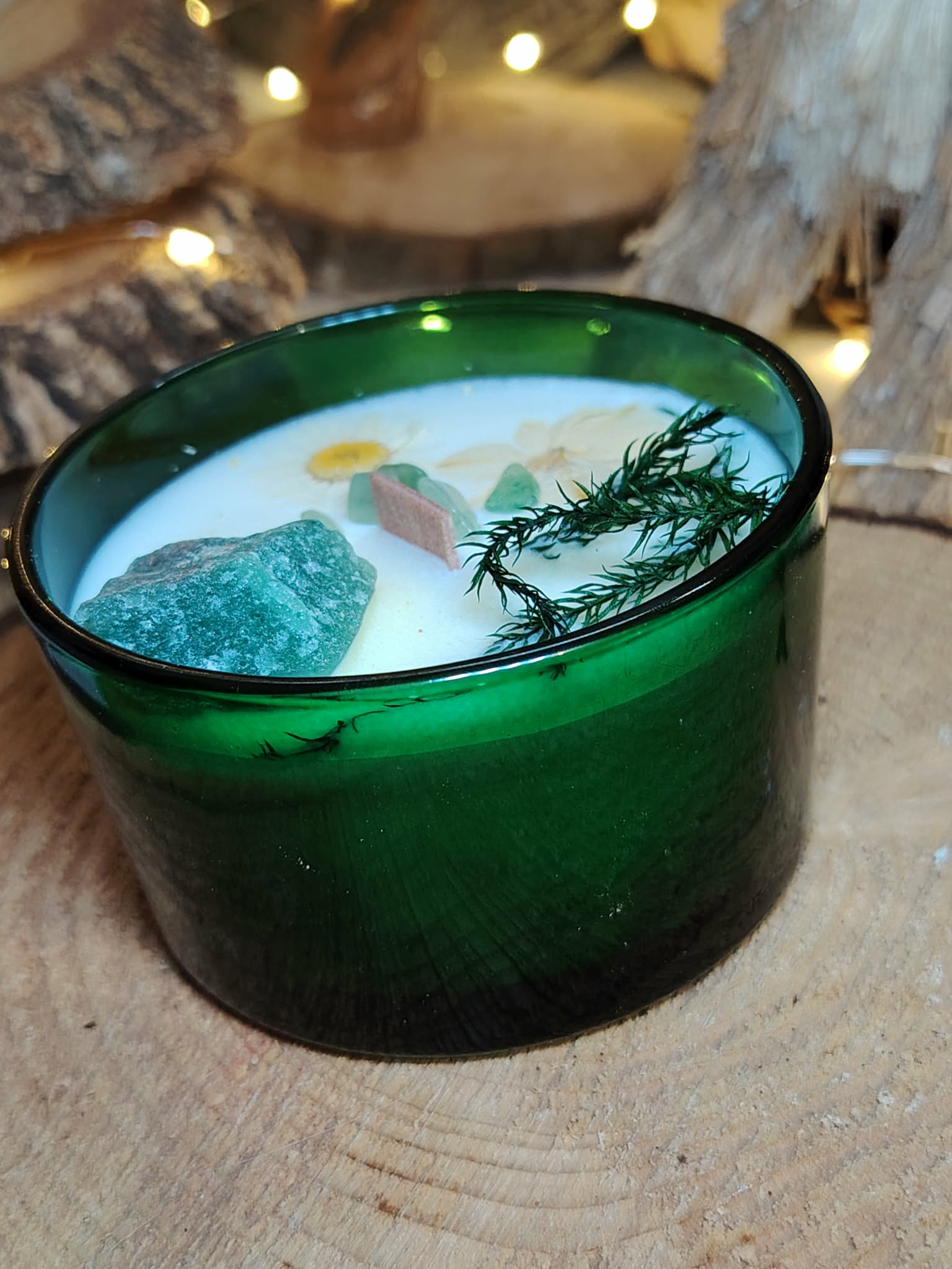 Bougie en verre vert, cire de soja parfum menthe-citron; pierre de jade et éléments botaniques visibles sur le dessus, ambiance cocooning