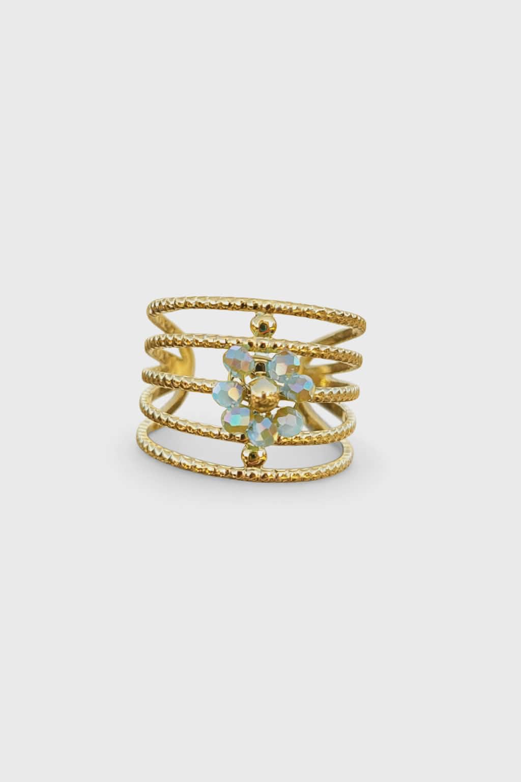 Bague ajustable dorée à plusieurs rangs texturés, en acier inoxydable cristaux bleus facettés effet irisé, gros plan produit sur fond blanc.