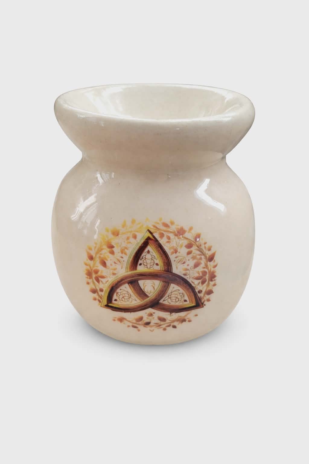 Brûle-parfum en céramique blanche vernissée sur fond blanc, forme ronde avec coupelle, motif triquetra et feuillage doré; évoque protection, ancrage, harmonie, ambiance apaisante pour huiles ou fondants parfumés.