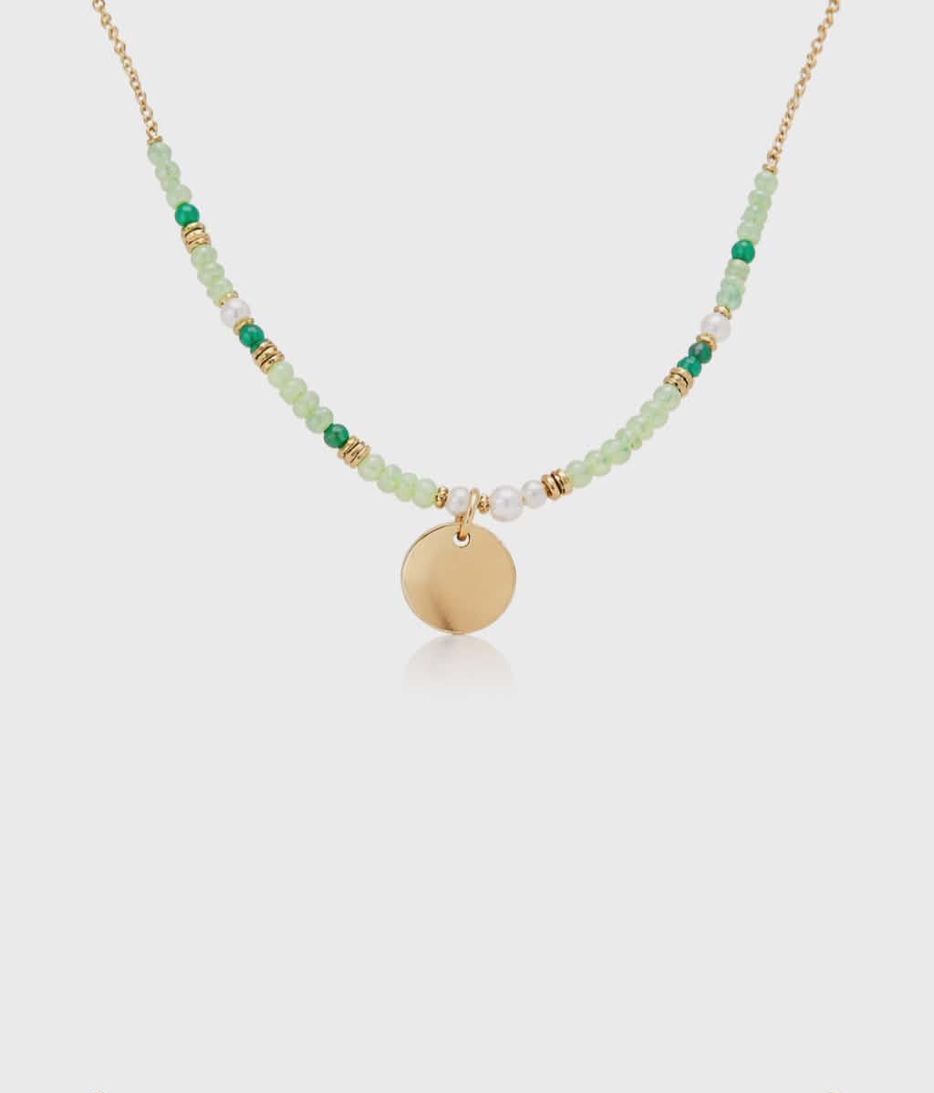 Collier doré en acier inoxydable sur fond clair, cristaux verts facettés et pendentif rond pour style délicat et touche lumineuse