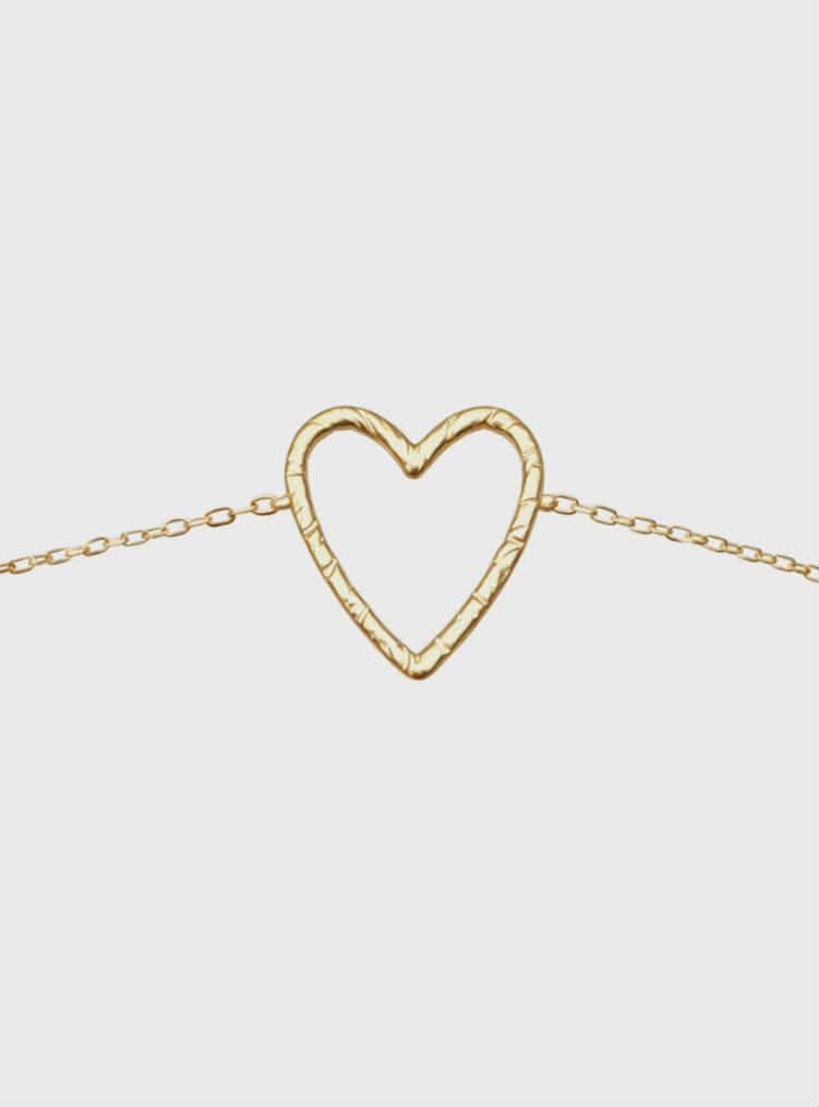 Bracelet chaîne fine en acier inoxydable doré, pendentif cœur ajouré; photo produit sur fond blanc, centré.