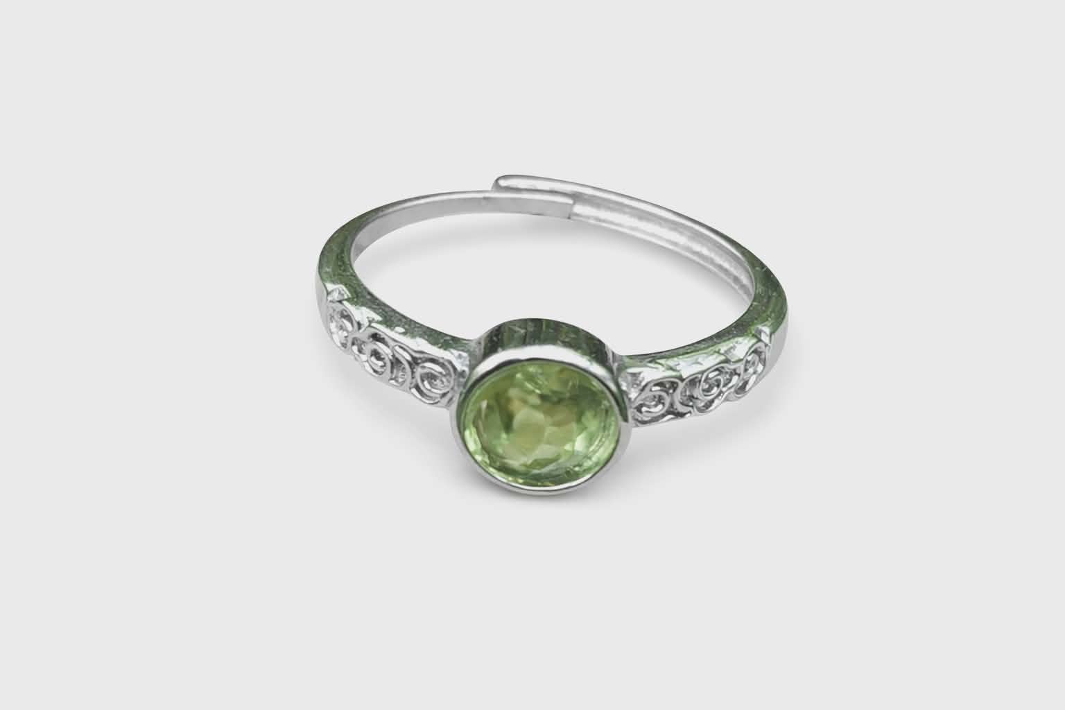 Bague péridot facetté, monture réglable cuivre blanc, sur fond blanc ; aide à se recentrer, à calmer les tensions et à garder le moral.