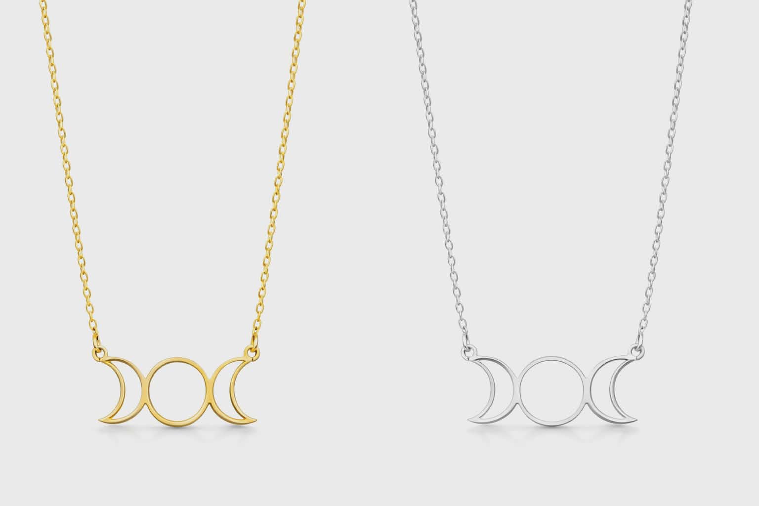 Deux colliers triple lune sur fond blanc, version dorée et argentée côte à côte, bijoux ésotériques inspirés des cycles lunaires