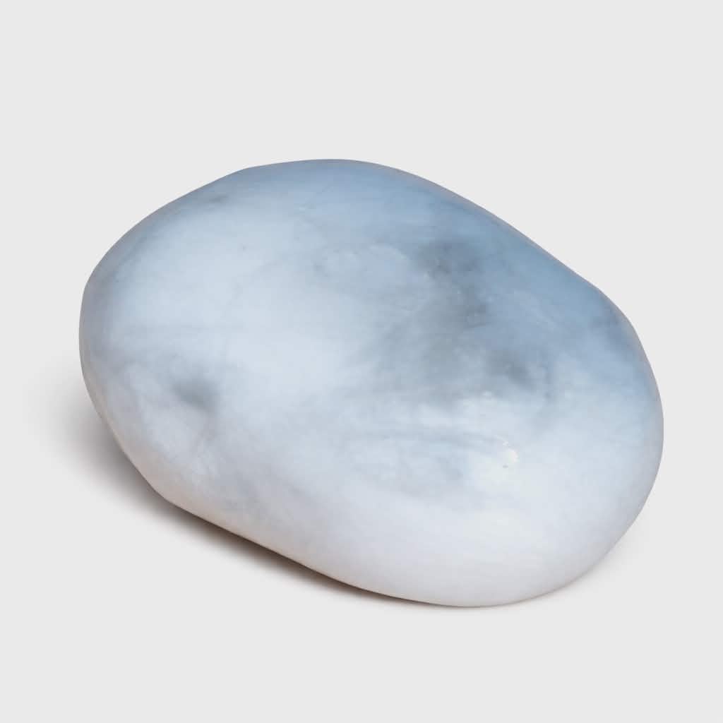 Pierre roulée howlite blanche et grise polie sur fond blanc, surface lisse légèrement nuagée avec ombre douce, pierre naturelle reliée au calme du mental, à l’expression posée et à l’équilibre intérieur.