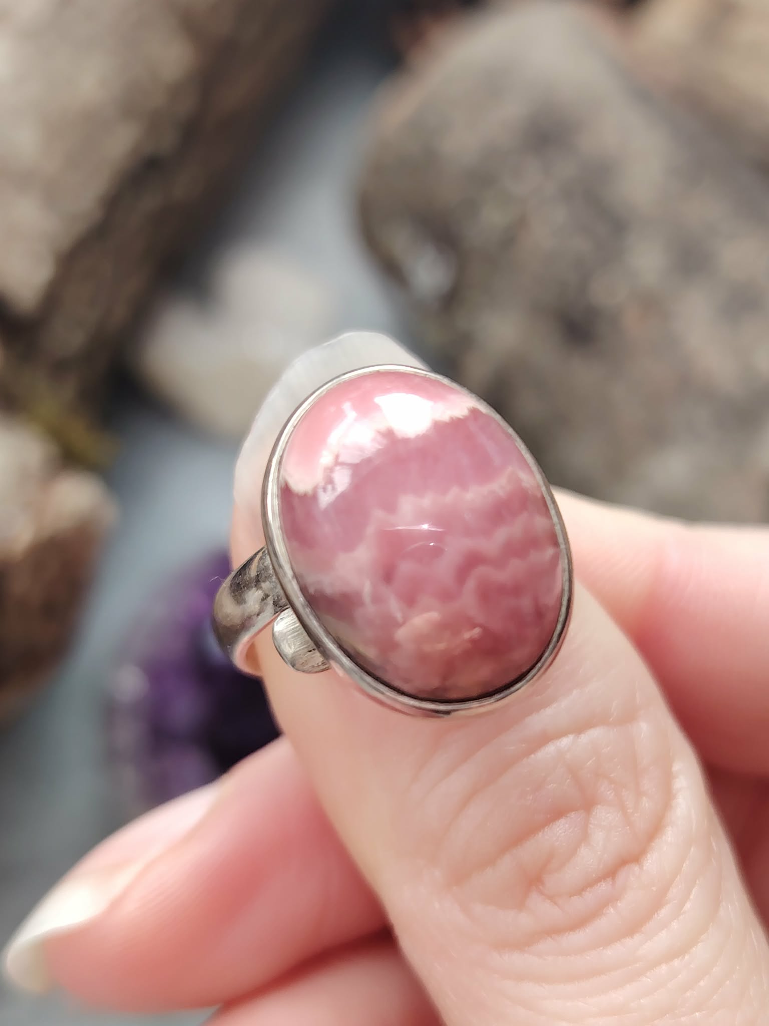 Bague rhodocrosite rose ovale en argent 925 réglable, portée au doigt; apporte douceur, apaisement, réconfort émotionnel.