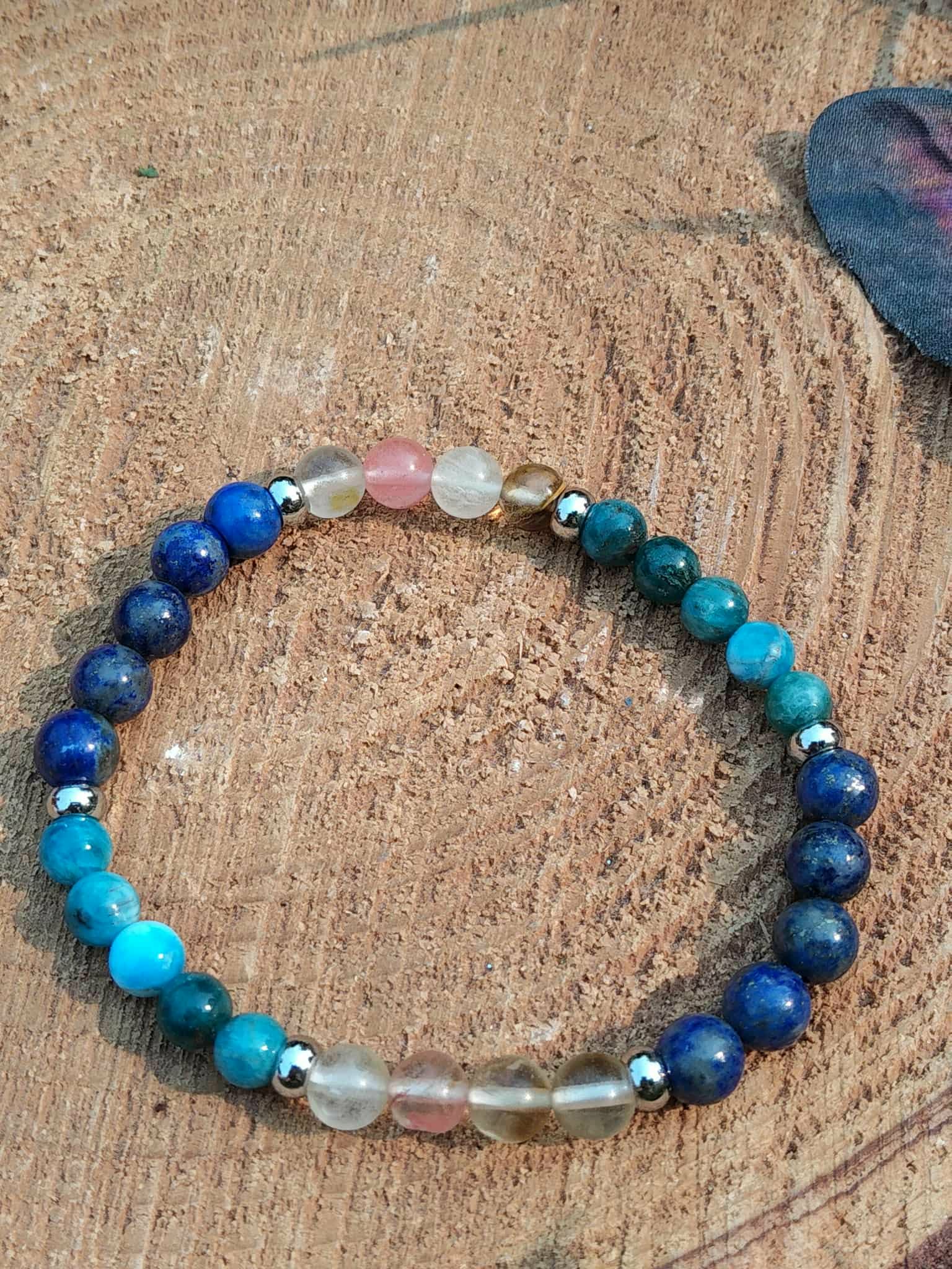 Bracelet minceur sur décor bois, lapis-lazuli bleu nuit, apatite bleu-vert et tourmaline melon d’eau avec intercalaires argentés pour discipline douce et équilibre émotionnel