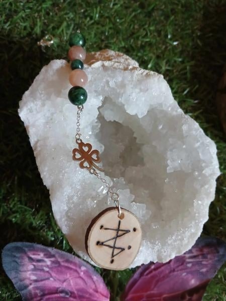 Bijou de rétroviseur sigil de chance (symbolisme : chance, protection, intention positive en route), perles vertes et pêche, pendentif bois gravé sur géode blanche et mousse. Création Magic Gaïa.