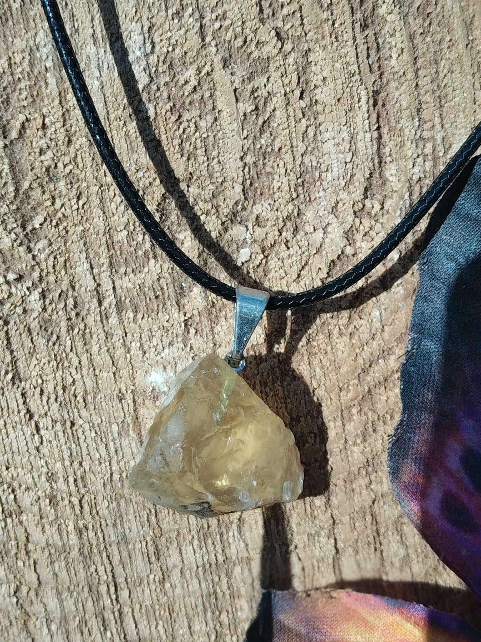 Pendentif citrine brute sur cordon noir, photo sur bois vieilli avec carte sombre en bord, pierre naturelle reliée à la volonté, à la présence à soi et à la chaleur réconfortante.