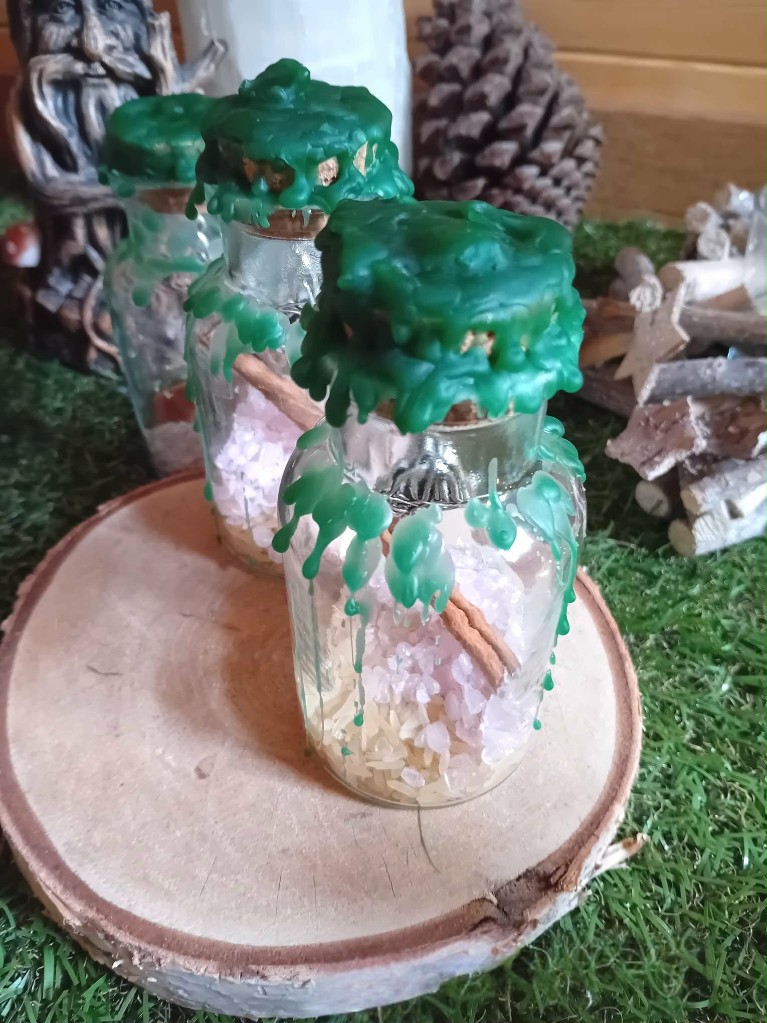 Spell jar d’abondance Magic Gaïa, 3 fioles en verre scellées cire verte, riz et bâton de cannelle, mise en scène sur tranche de bois
