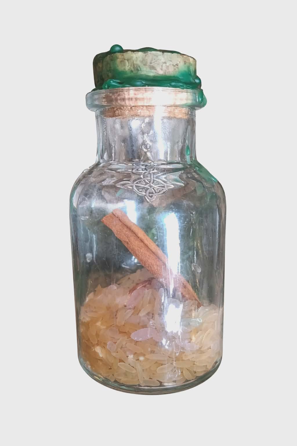 Spell jar abondance Magic Gaïa sur fond blanc, fiole en verre avec cire verte, riz et bâton de cannelle