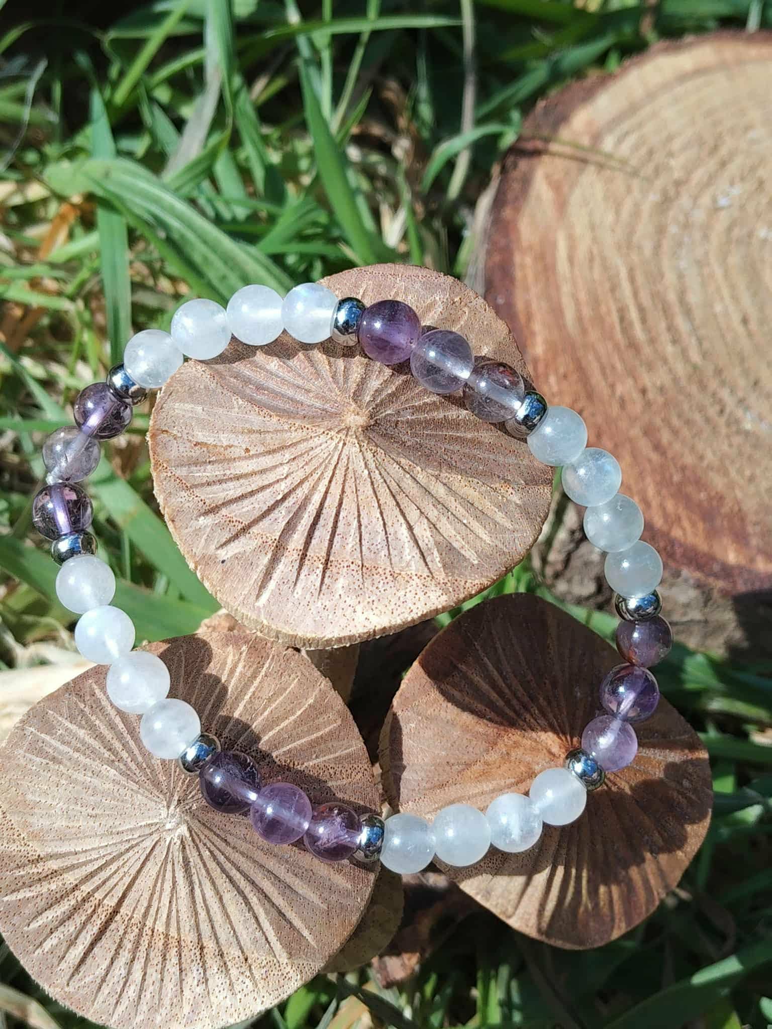 Bracelet clairvoyance en pierres naturelles posé sur champignons et herbe, création Magic Gaïa en Quartz Seven et Péristérite, écoute intérieur
