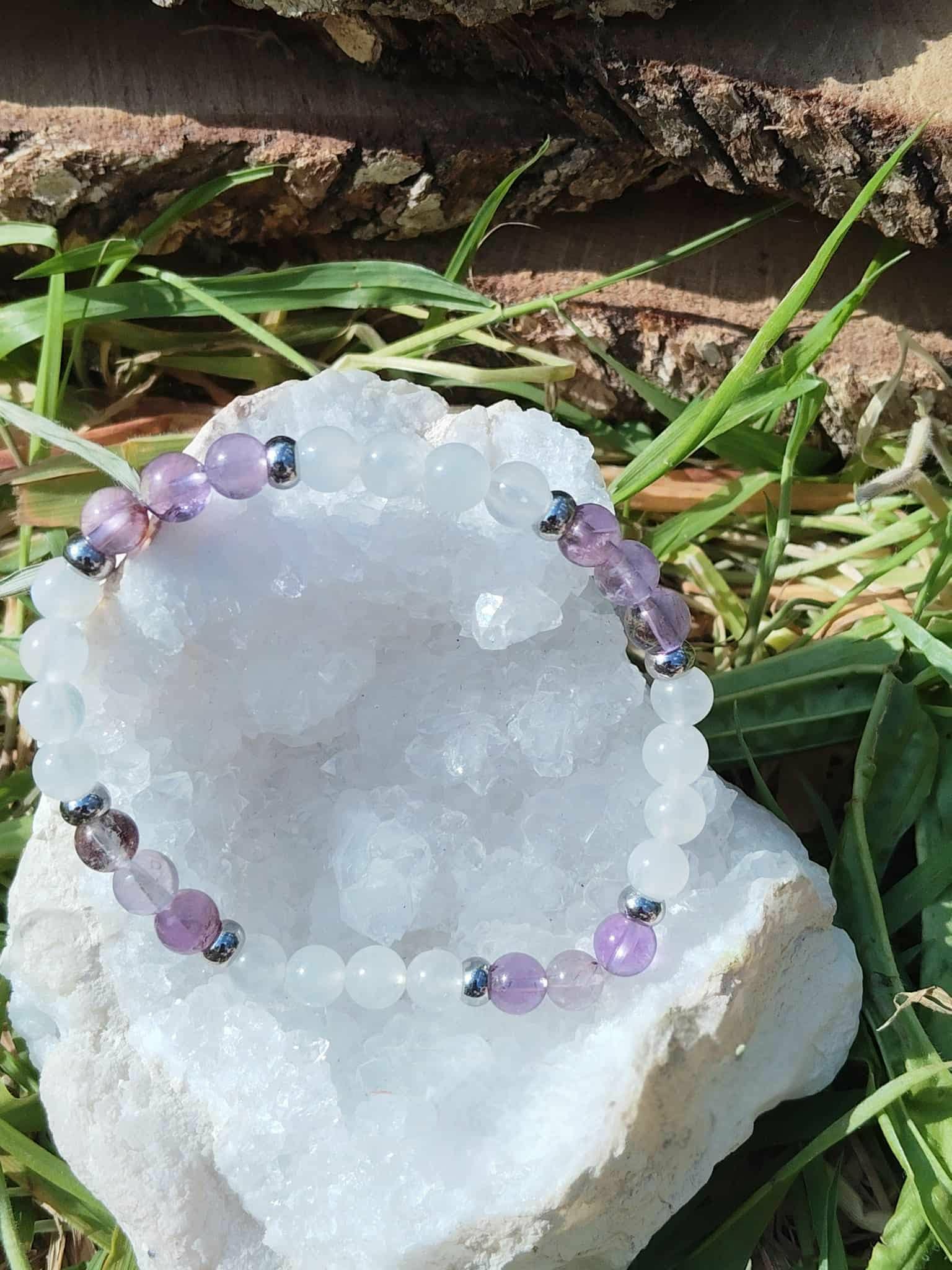 Bracelet clairvoyance Magic Gaïa sur amas de quartz blanc dans l’herbe, Quartz Seven et Péristérite, clarté mentale et protection douce