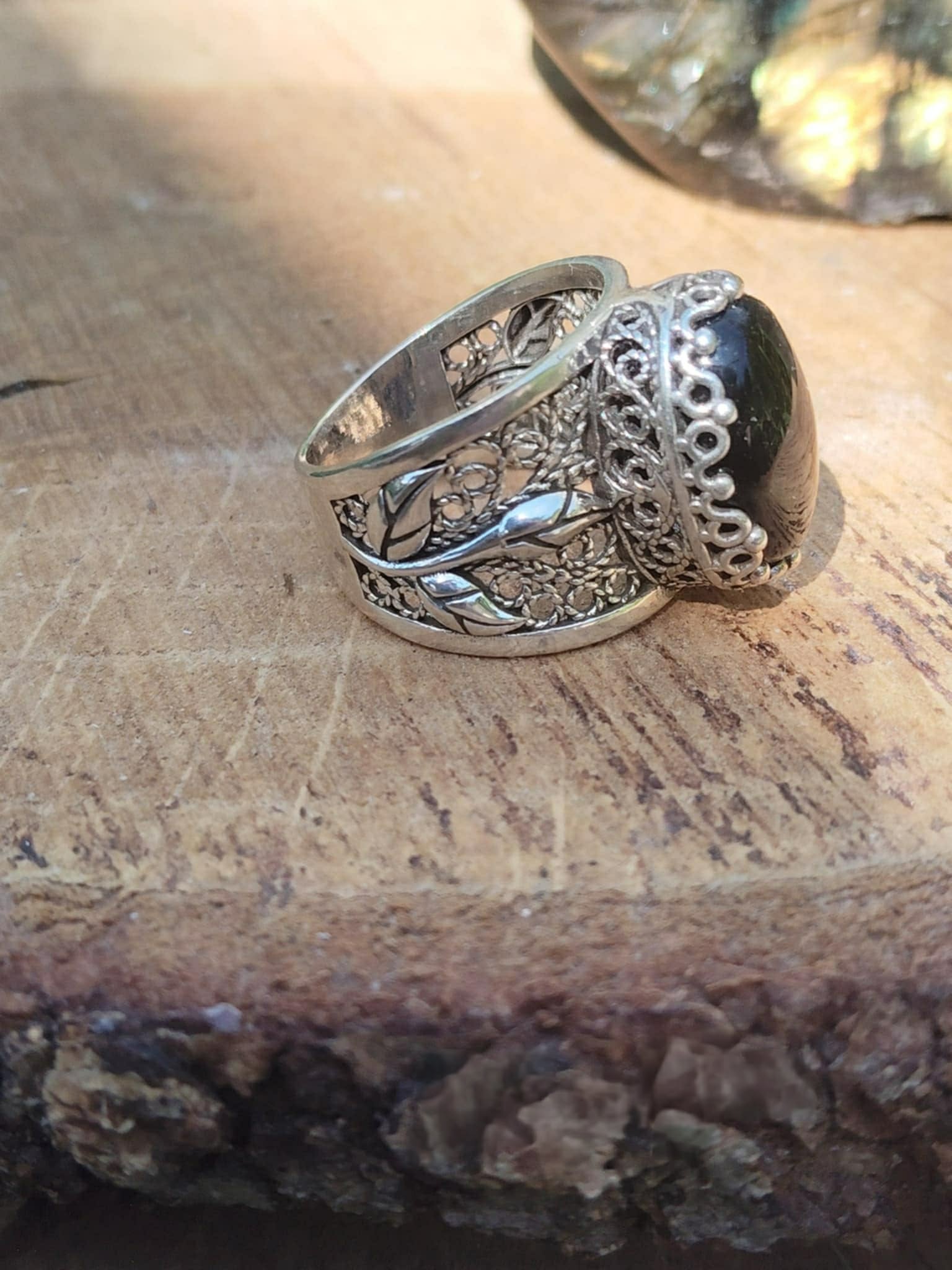 Bague argent 925 filigrane onyx noir vue de profil posée sur tranche de bois décor naturel intentions associées protection ancrage stabilité