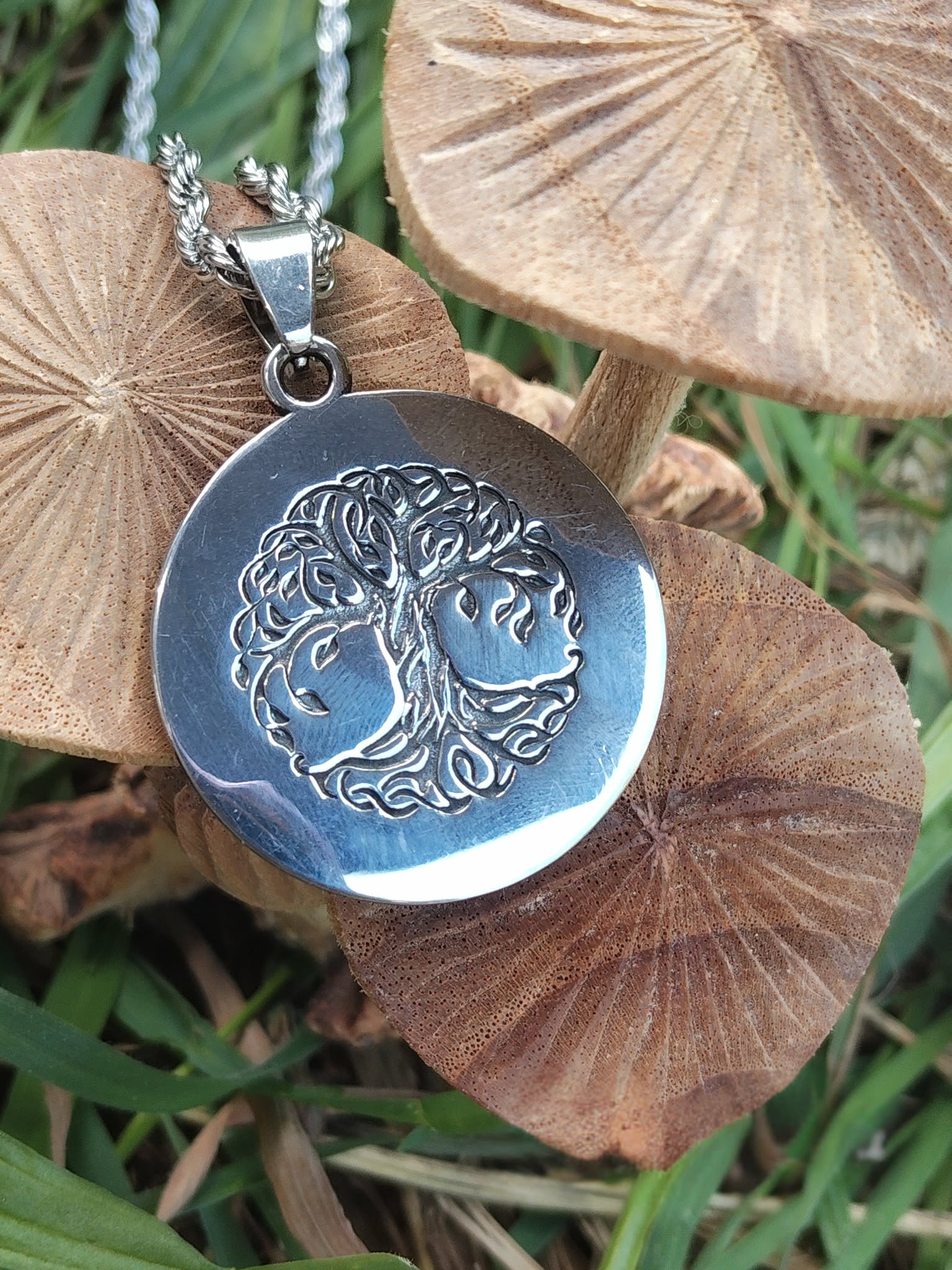 Pendentif arbre de vie aux motifs celtiques sur champignons en décor extérieur, ancrage doux, stabilité et recentrage du ressenti