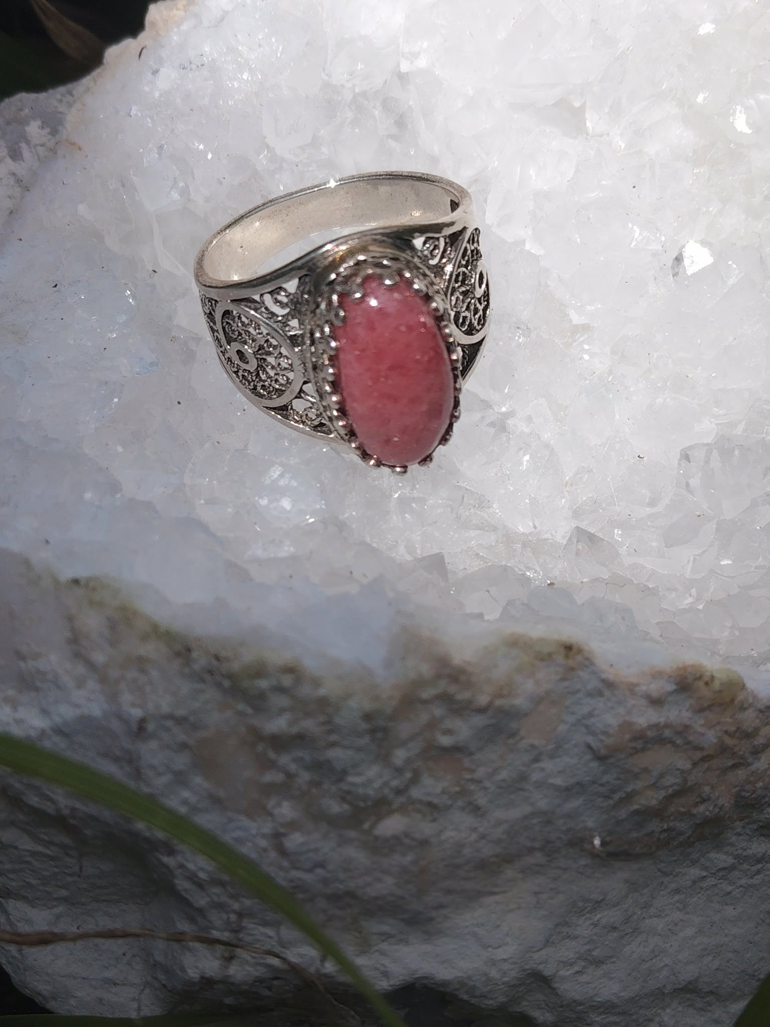 Gros plan bague rhodonite rose ovale sertie argent 925 filigrané sur amas de quartz blanc intentions calme intérieur protection émotionnelle
