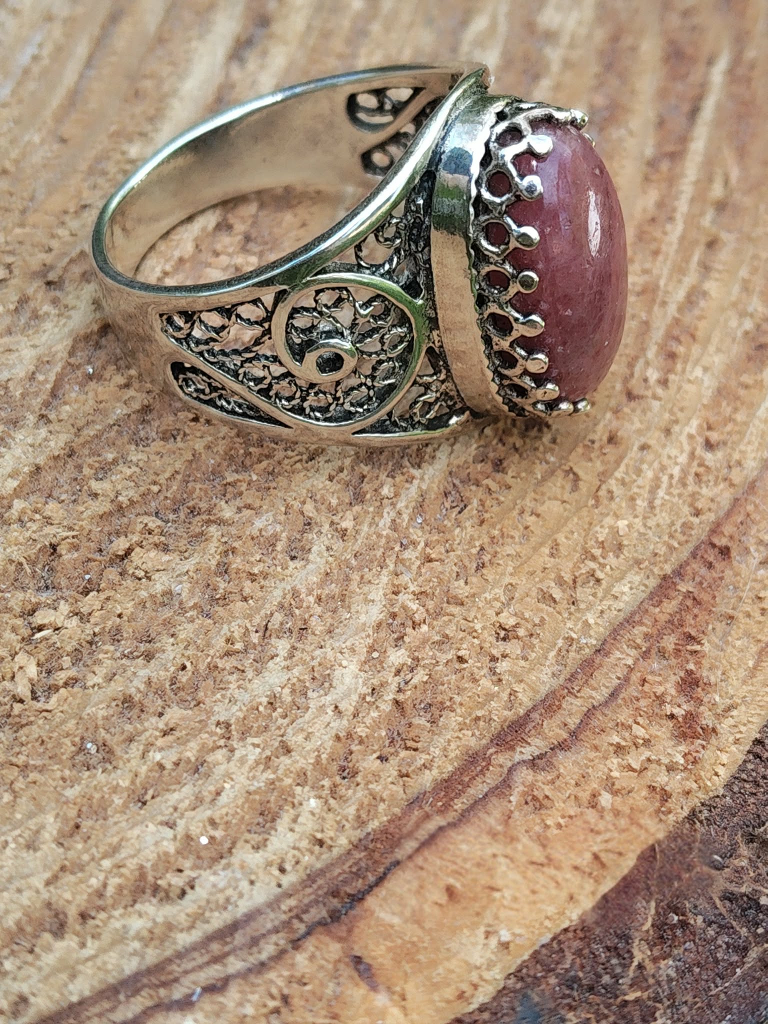 Bague argent 925 filigrane rhodonite ovale rose vue latérale anneau ouvert décor bois clair intentions calme intérieur recentrage