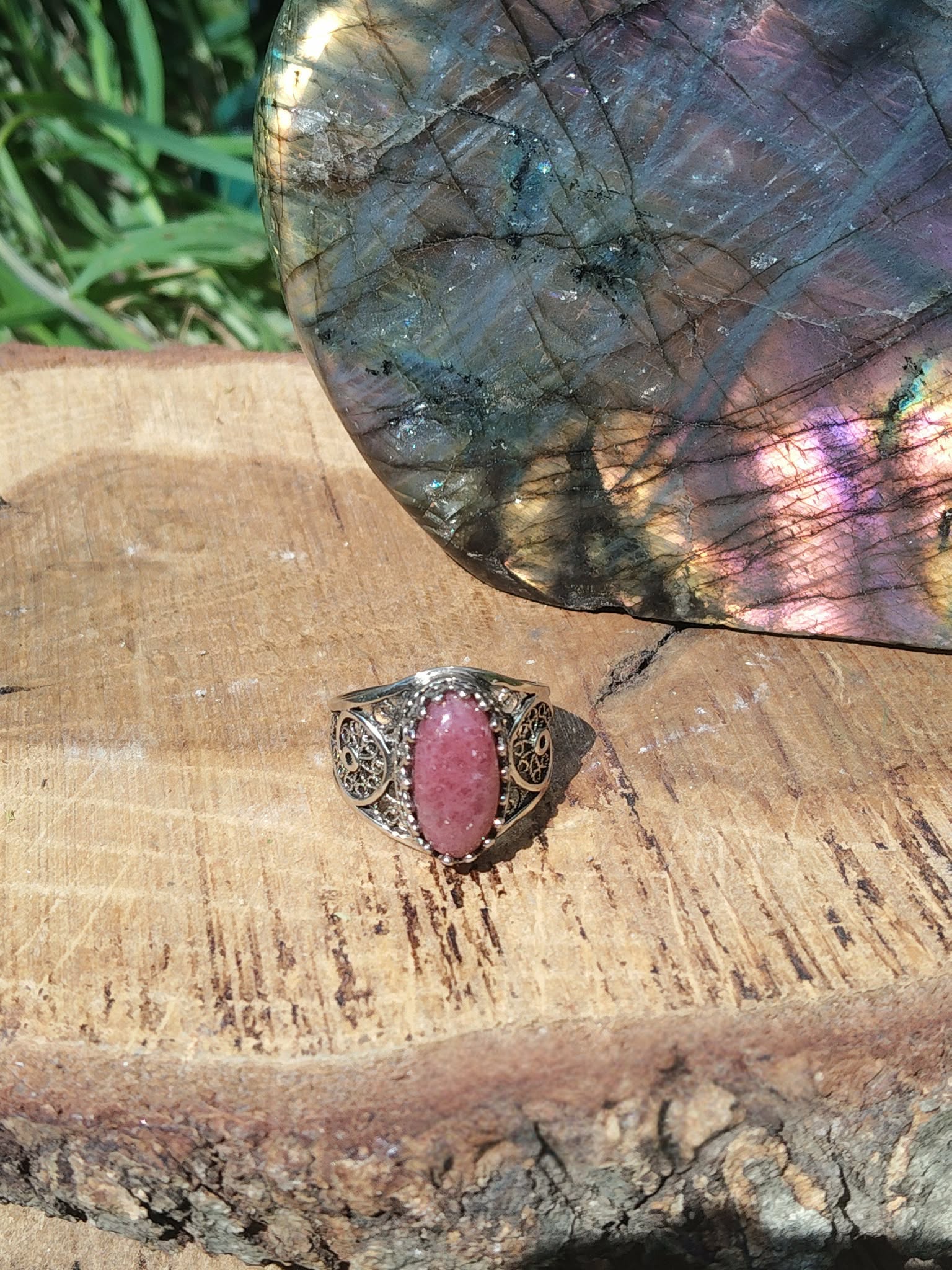 Bague argent 925 filigrane rhodonite ovale rose sur support bois nature avec pierre labradorite en décor intentions sérénité confiance