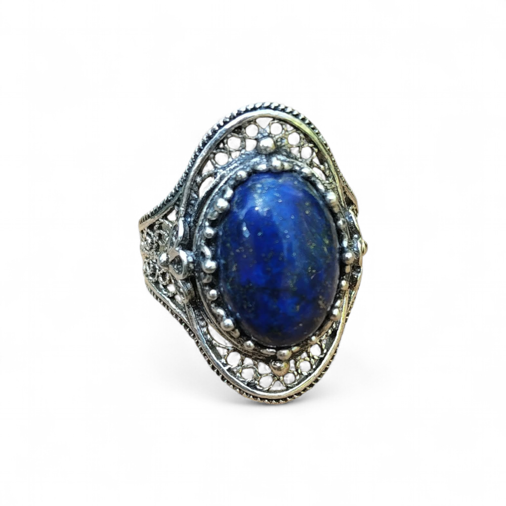 Bague en argent 925 filigranée, cabochon ovale en lapis lazuli bleu profond, isolée sur fond blanc, intention clarté, calme et expression.
