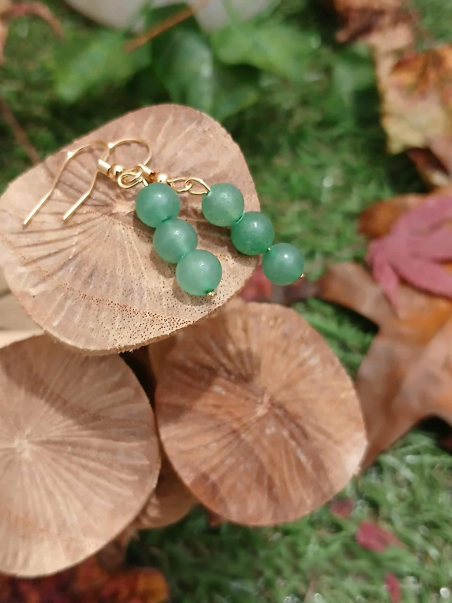 Boucles d’oreilles création Magic Gaïa en aventurine verte, trois perles sur crochets dorés, posées sur trois champignons beiges, pour apaisement et optimisme.
