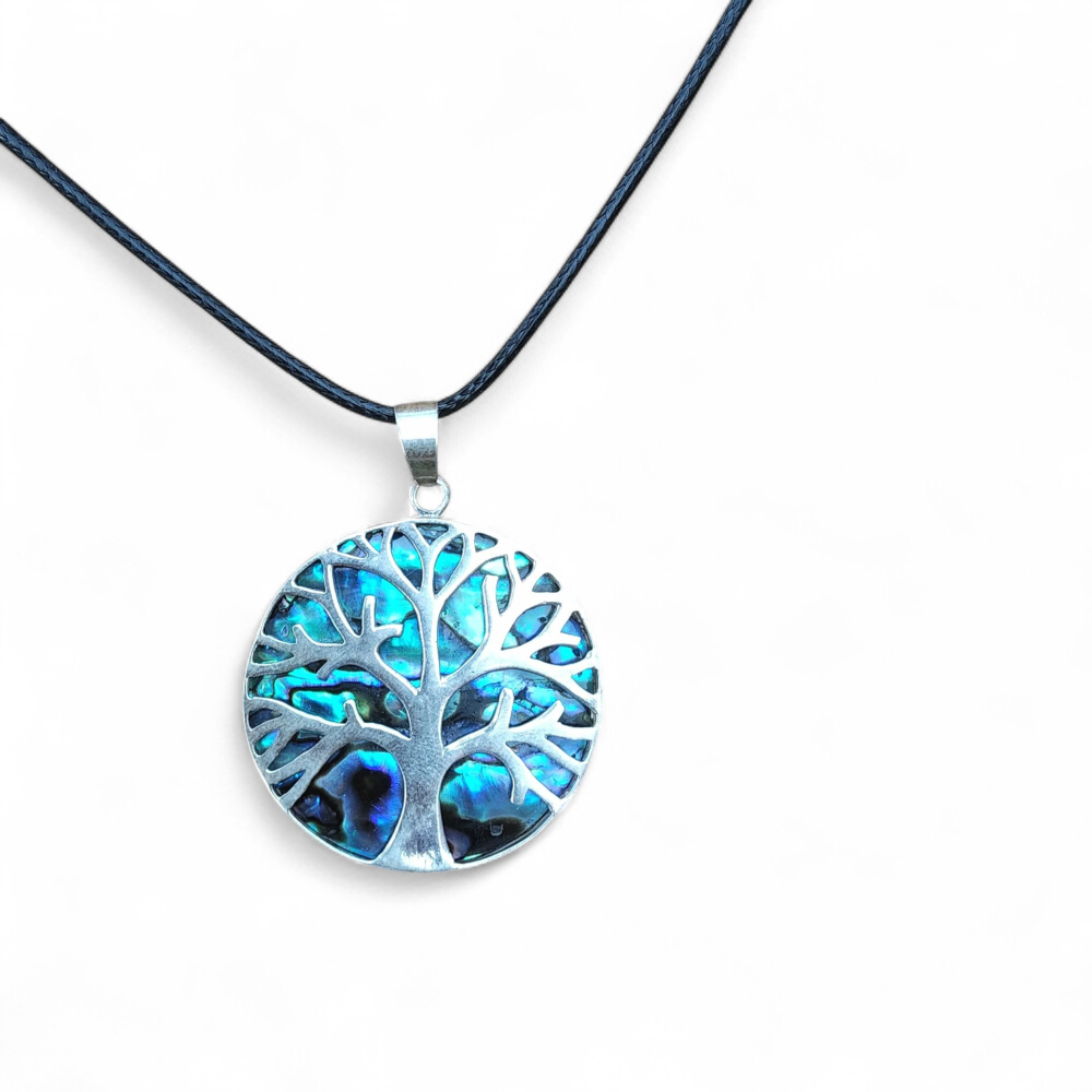 Pendentif arbre de vie en abalone et argent 925 sur cordon noir, photographié sur fond clair, bijou en nacre naturelle relié à la sérénité, à la fluidité émotionnelle et à l’élégance.