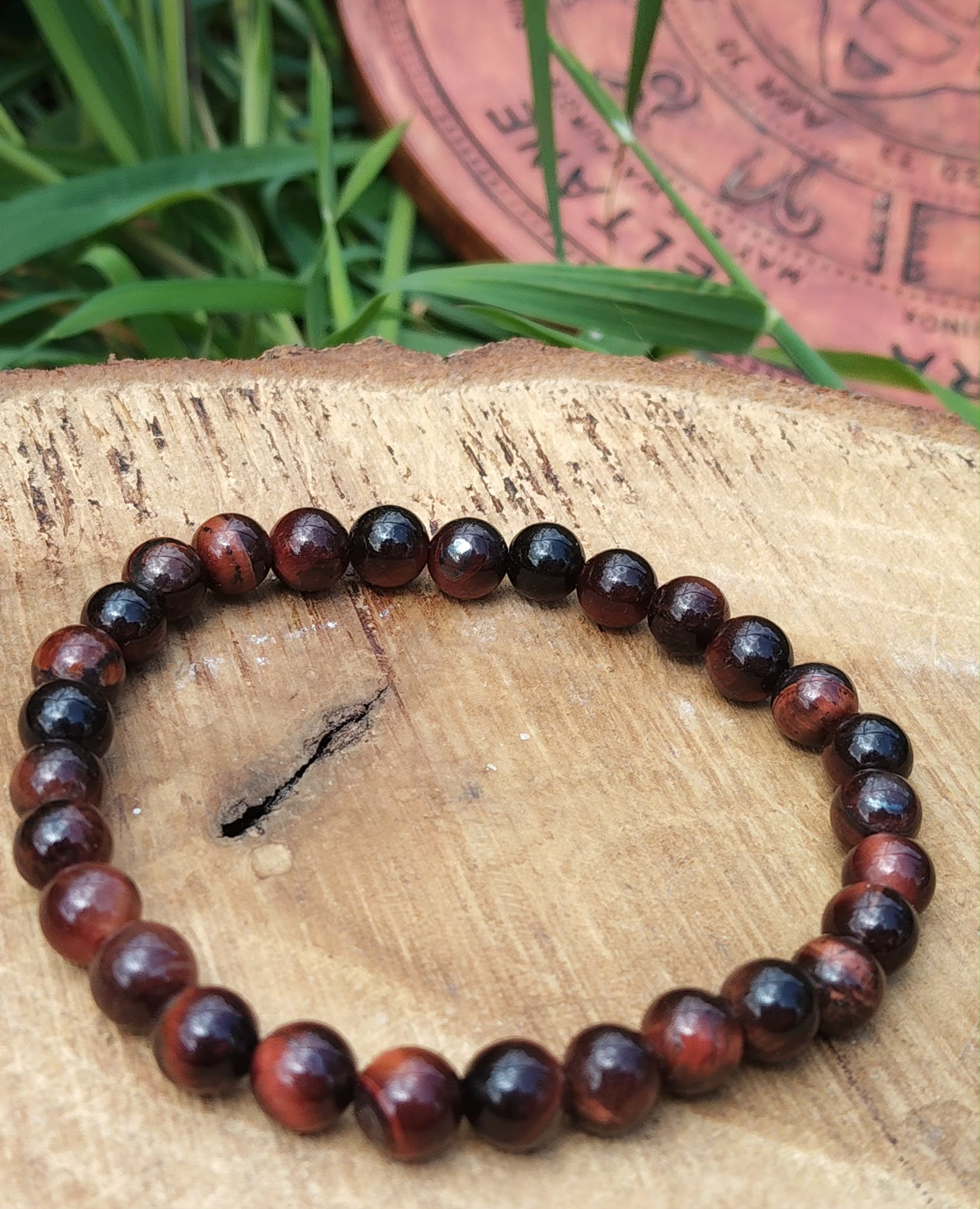 Bracelet œil de taureau 6 mm sur tranche de bois avec brins d’herbe, courage posé, enracinement solide et présence affirmée