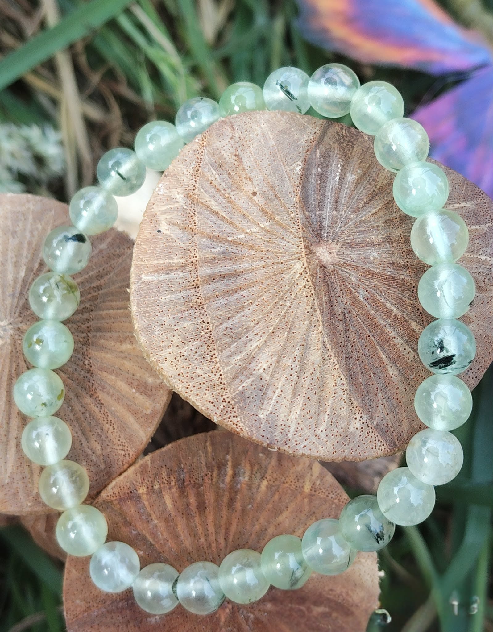 Bracelet préhnite 6 mm sur champignons décoratifs avec touche violette en fond, douceur mentale, intuition fine et paix intérieure