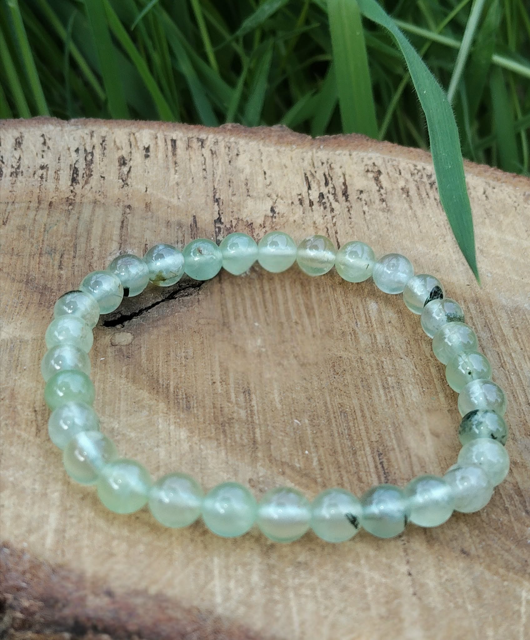 Bracelet préhnite 6 mm sur rondin de bois avec feuillage vert, perles vert d’eau translucides pour sérénité intérieure, discernement et calme du mental