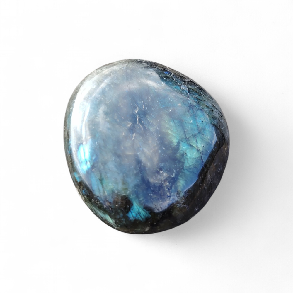 Galet de labradorite aux reflets bleus sur fond blanc, pierre polie reliée à la lucidité, au calme intérieur et à la finesse intuitive.