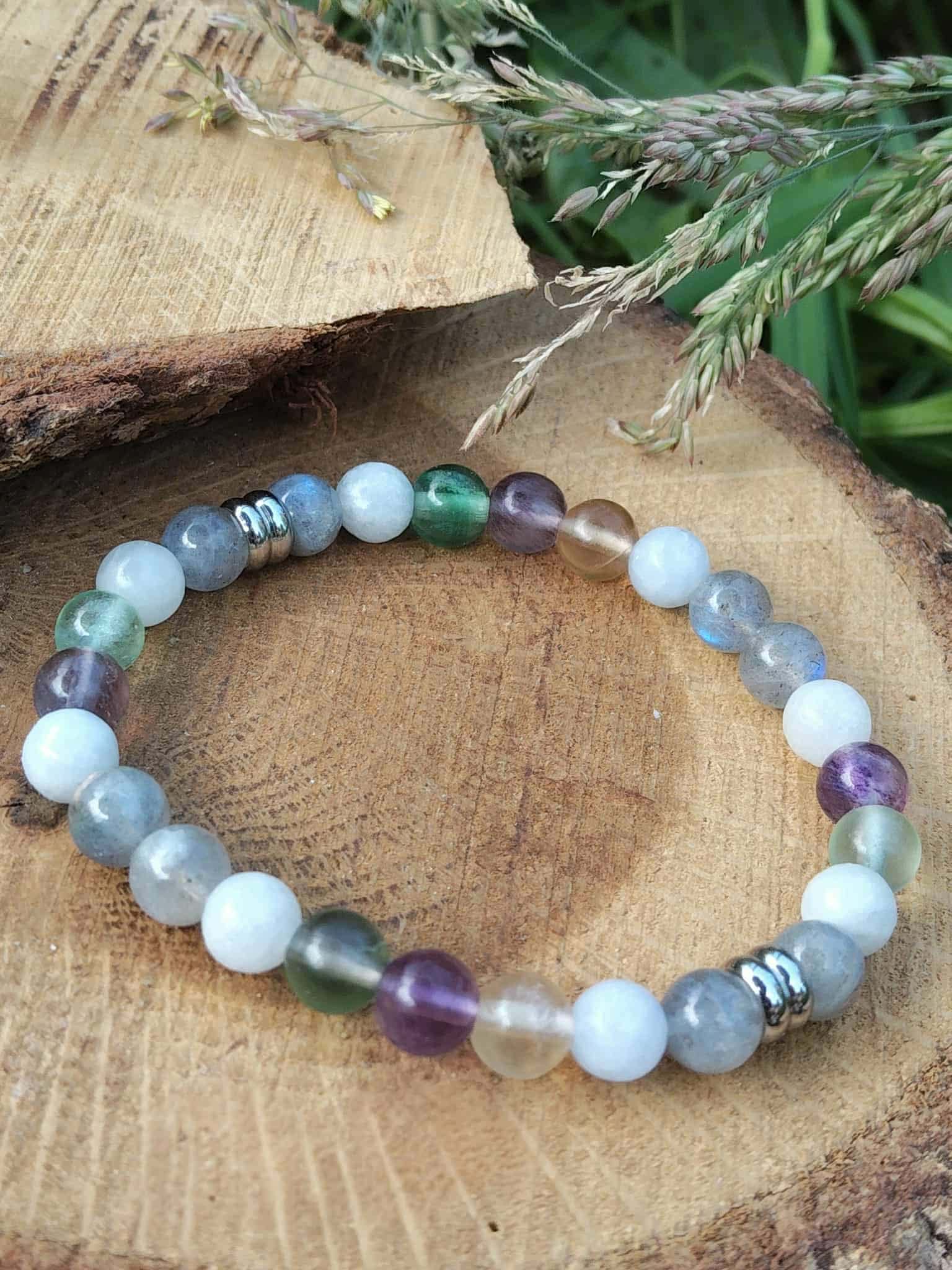 Perles bleu-gris, vertes et violettes du bracelet Énergie lunaire sur rondelle de bois avec branche de sapin, douceur et intuition