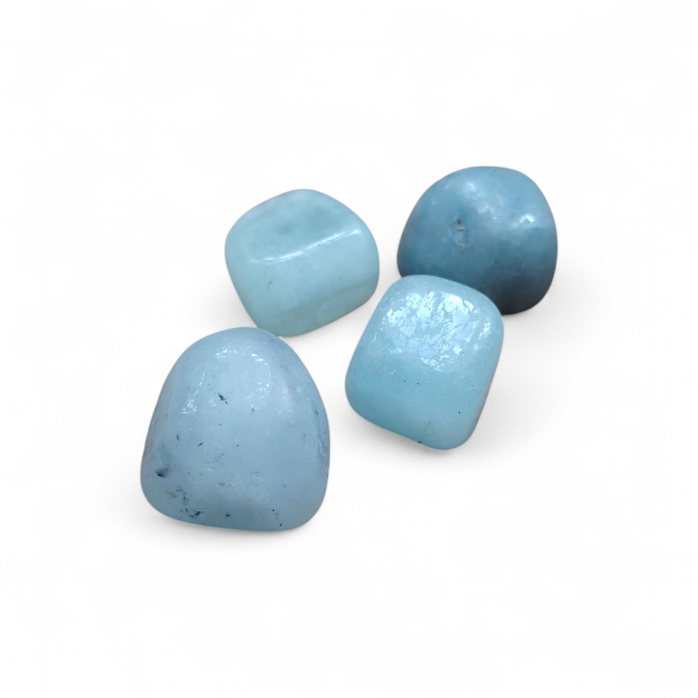 quatre-pierres-roulées-d-aigue-marine-bleu-pastel-posees-sur-fond blanc pour-apaiser-le-mental-et-faciliter-une-communication-douce