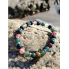 Bracelet chakra cœur 6 mm en agate mousse et tourmaline melon d’eau sur rochers en Bretagne près de l’eau, harmonie affective, douceur du cœur et apaisement intérieur