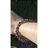 Bracelet jaspe dalmatien 6 mm porté au poignet sur fond sombre, perles crème et ivoire tachetées de noir pour stabilité, ancrage léger et confiance calme