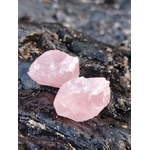 Deux quartz rose bruts posés sur rocher sombre au bord de mer en Bretagne, texture granitique visible, pierres naturelles associées au réconfort, à la paix émotionnelle et à la délicatesse du cœur.