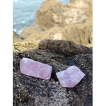 Deux quartz rose bruts posés sur rocher sombre en bord de mer en Bretagne, pierres naturelles évoquant l’amour de soi, la douceur émotionnelle et le calme intérieur.