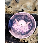Brûleur d’encens rond violet motif Triple Lune posé sur rocher près de la mer en Bretagne; fumigation, atmosphère apaisante et protection symbolique.