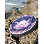 Brûleur d’encens rond violet Triple Lune sur rocher face à la mer en Bretagne; fumigation, ambiance apaisante et protection symbolique.
