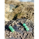 Boucles d’oreilles en aventurine verte, création Magic Gaïa, en gros plan sur rocher breton, ambiance bord de mer, pour apaisement et optimisme.