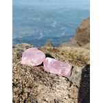 Deux quartz rose bruts posés sur un rocher face à la mer en Bretagne, pierres naturelles associées à la douceur intérieure, au réconfort et à la paix du cœur.