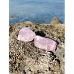Quartz rose brut sur rocher breton au bord de l’eau, teintes rose pâle naturelles et ambiance marine, pierre naturelle associée à l’écoute de soi, au réconfort et à la paix du cœur.