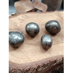 Quatre pierres roulées de pyrite aux reflets métalliques dorés posées sur une tranche de bois, pour soutenir confiance, protection et clarté.