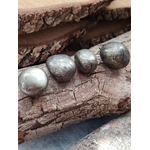 Quatre pierres roulées de pyrite aux reflets métalliques dorés posées sur du bois naturel, éclats lumineux, pour inviter à la protection, la confiance en soi et la clarté mentale.