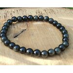 Bracelet obsidienne œil céleste 6 mm en perles noires sur planche de bois clair avec petite brindille, solidité, discernement et clarté mentale